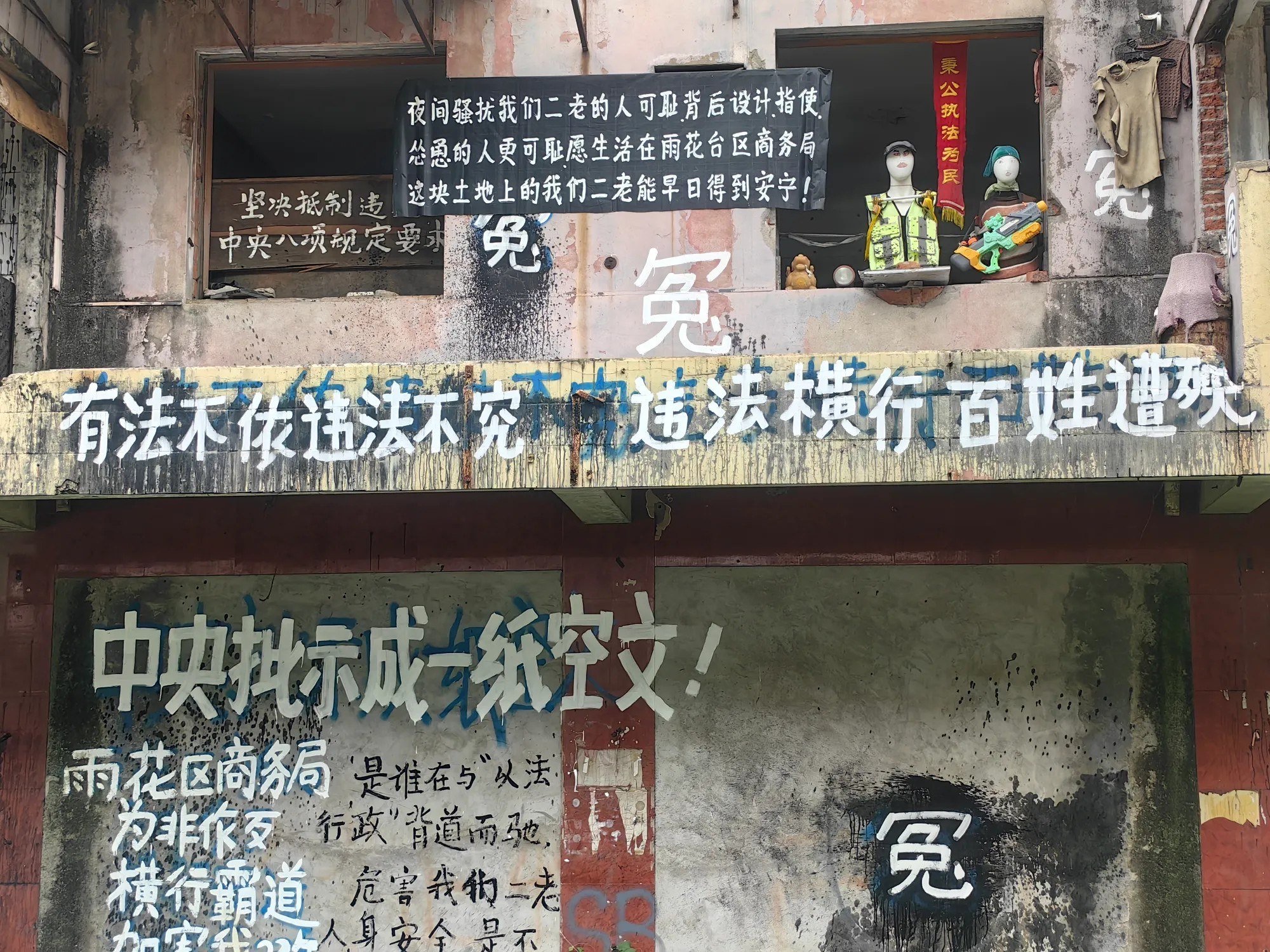 2026年9月11日,一网友晒出一组抗议照片
照片中,一栋破旧楼房挂满黑底白字的控诉横幅,墙上多处写着“冤”字,以及“中央批示成一纸空文”“
